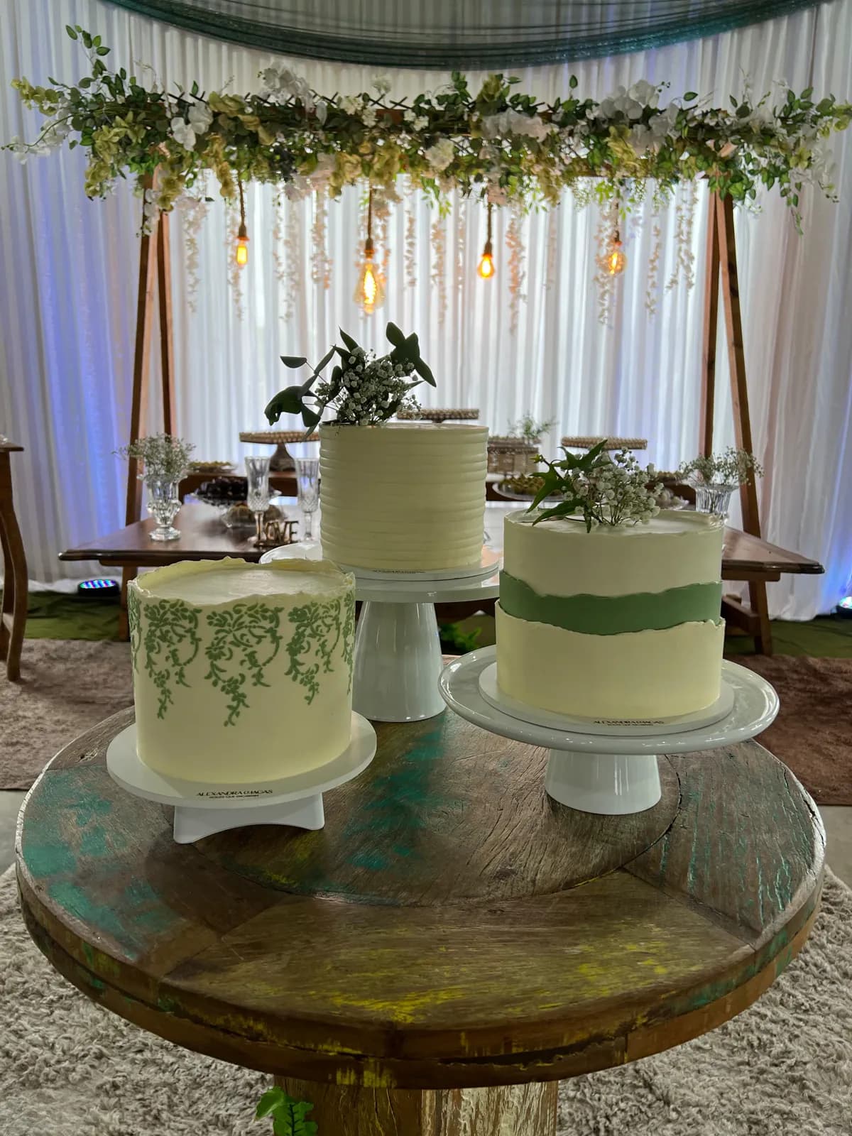 Três bolos em uma mesa de celebração decorada