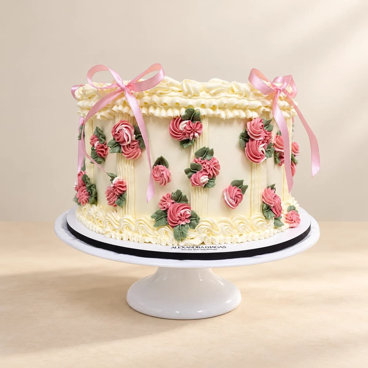 Bolo branco com flores cor-de-rosa e laços, em fundo creme
